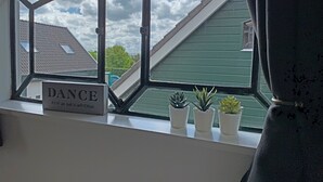 A window with a sign reading "DANCE AS IF NO ONE IS WATCHING" and three potted plants on the windowsill. - Christinahoeve Hooiberg #5 (Boskoop)