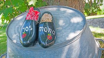 Two painted shoes with the text "jos mona" on a metal barrel.