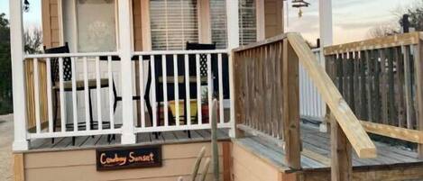 Guests can enjoy a peaceful stay at Cowboy Sunset, featuring a porch with a staircase leading to the entrance.