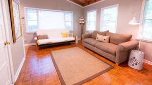 Un salon avec un canapé, un divan, un tapis et une lampe.