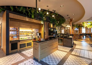 A modern kitchen with a central island, a buffet area, and a seating area with chairs and tables. - Point A Dublin Parnell Street (Dublin)