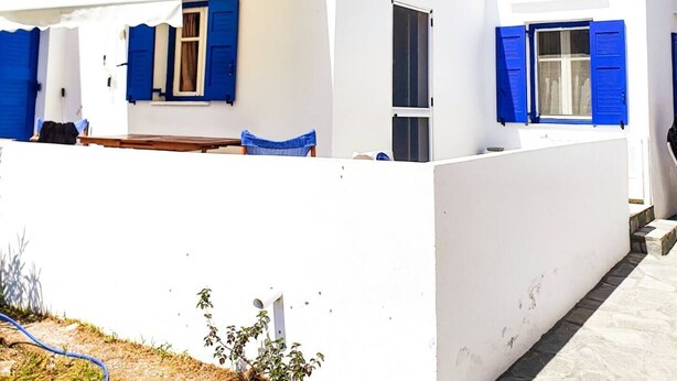 A white building with blue shutters and a clear blue sky. - Antonis House (Sifnos)