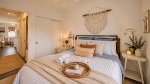 A bedroom with a bed, bedside tables, a wall hanging, and a potted plant. - Sonoma Wine Country Retreat | Near Top Wineries + Cozy Escape (Santa Rosa)
