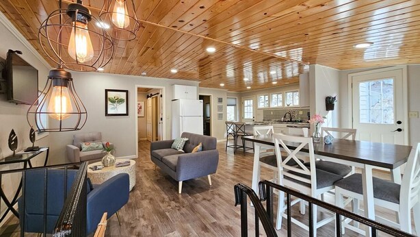 A spacious living area with a wooden ceiling, a dining table with chairs, and a sofa. - Hill house 2 bedroom, 2 bath house. Walk to downtown Hill City, SD (Hill City)