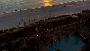 Un resort con piscina, playa y vistas al atardecer.