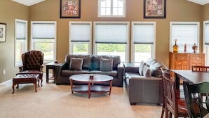 A spacious living room with a high ceiling, large windows, a ceiling fan, and a dining area. - Resort condo close to hiking and river/lake (Thornton)