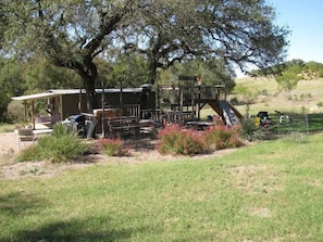 Enjoy dining and socializing in this charming outdoor space with a covered area and staircase to a lookout.