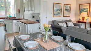 Un espacio habitable compacto con comedor, kitchenette y zona de estar.