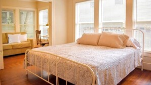 A bedroom with a bed, a sofa, and a chair.