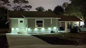 Ein zweistöckiges Haus mit Veranda und Garage.