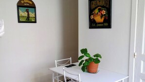 A dining area with a white table and chairs, a potted plant, and two wall decorations. - Apartment with garden near Maisons-Alfort veterinary school, metro 8 (Maisons-Alfort)