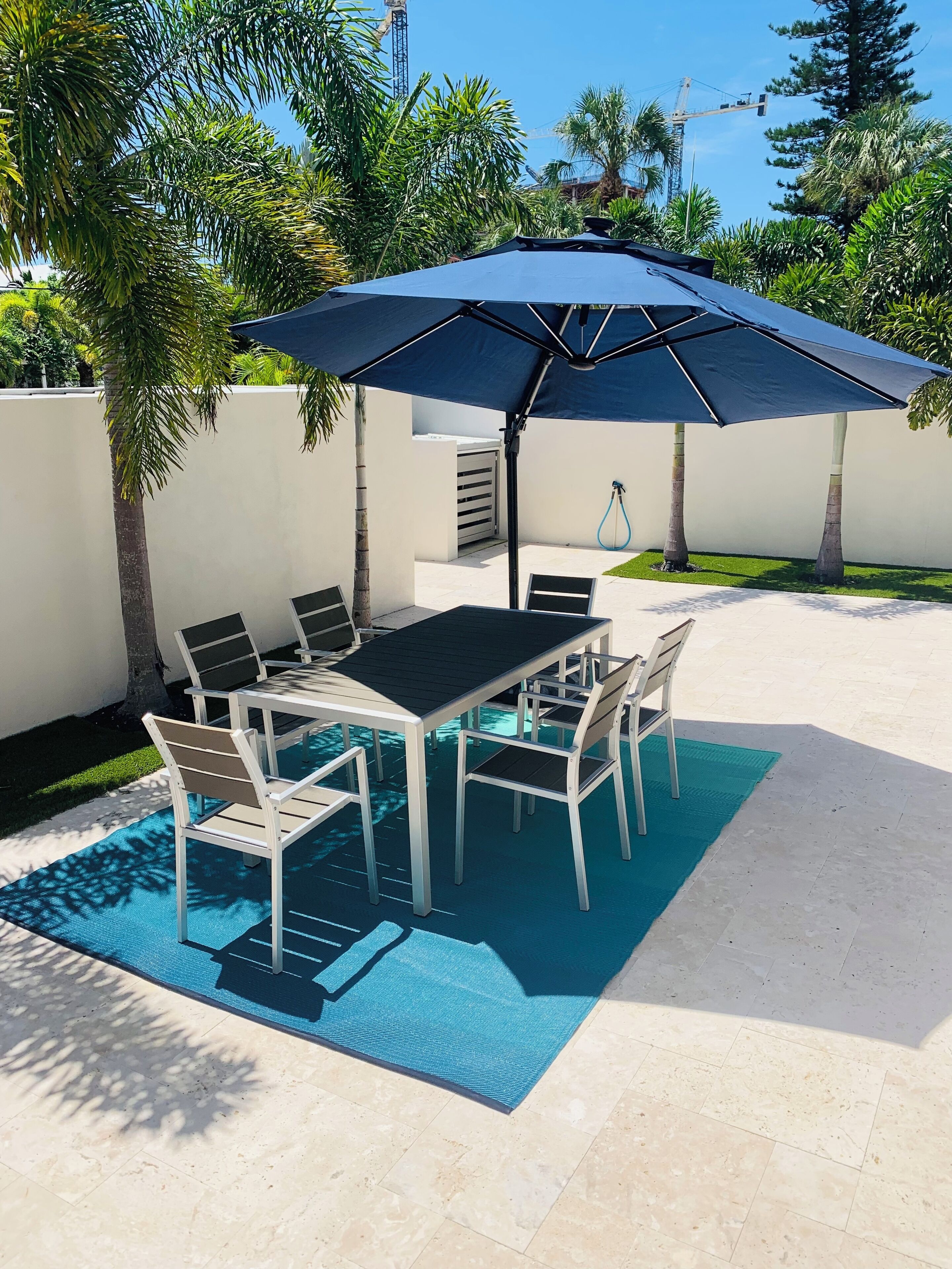 Une terrasse avec une table de billard, des chaises et un grand parasol.