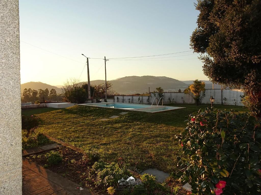 Un patio trasero con piscina, césped y vistas a colinas distantes.