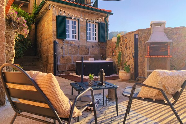 A stone building with a hot tub, outdoor seating, and a chimney. - Regouro - an Hidden Gem in Douro Valley (Cinfães)