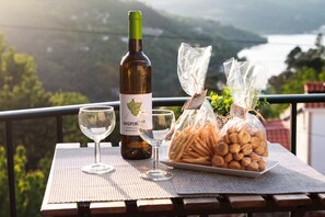 A table with a bottle of wine, two wine glasses, and a plate of snacks on a balcony with a scenic view. - Regouro - an Hidden Gem in Douro Valley (Cinfães)