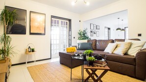 A modern living room with a brown sofa, a coffee table, and a side table with a plant. - Regouro - an Hidden Gem in Douro Valley (Cinfães)