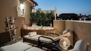 Une terrasse sur le toit équipée d’un jacuzzi, de chaises longues et d’un mur végétal décoratif.