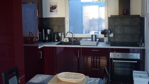 A modern kitchen with a skylight, stainless steel appliances, and a view through the window. - LA GABARDISE (Plouarzel)