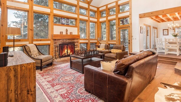 A spacious living room with a fireplace, large windows, and a cozy seating area. - RAVEN WOOD, 400 FT TO SKI RUNS, HOT TUB, SAUNA, PRIVATE (Sundance)