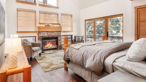 A bedroom with a fireplace, a bed, a sofa, and a window with blinds. - RAVEN WOOD, 400 FT TO SKI RUNS, HOT TUB, SAUNA, PRIVATE (Sundance)