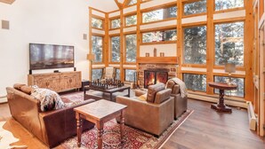 A spacious living room with a fireplace, large windows, and a cozy seating area. - RAVEN WOOD, 400 FT TO SKI RUNS, HOT TUB, SAUNA, PRIVATE (Sundance)