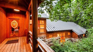A rustic cabin with a wooden exterior, a porch with a bench, and a metal roof. - RAVEN WOOD, 400 FT TO SKI RUNS, HOT TUB, SAUNA, PRIVATE (Sundance)