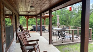 Une terrasse en bois avec des sièges d’extérieur et un jacuzzi.