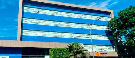A hotel building with a sign 'hoteles MX' and a storefront with 'miguel potros' signage.