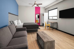 A modern room with a bed, a sofa, a desk, and a TV. - Hotel MX forum buenavista CDMX, Trademark by Wyndham (Mexico City)