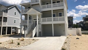 Un edificio residencial de varios pisos con un porche cubierto y una escalera que conduce a los pisos superiores.