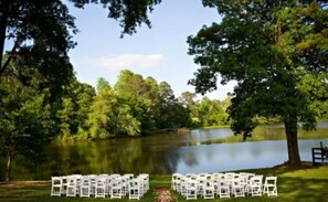 A serene outdoor setting with a lake, surrounded by lush greenery and trees. - Events&Pets 👍 * Weddings* Retreats*Nature*Hot Tub w/ central location! (Cumming)