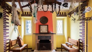 Una habitación acogedora con chimenea, bancos de madera y un reloj sobre la repisa.