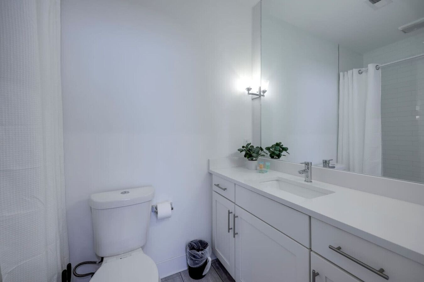 A modern bathroom with a toilet, sink, and mirror.