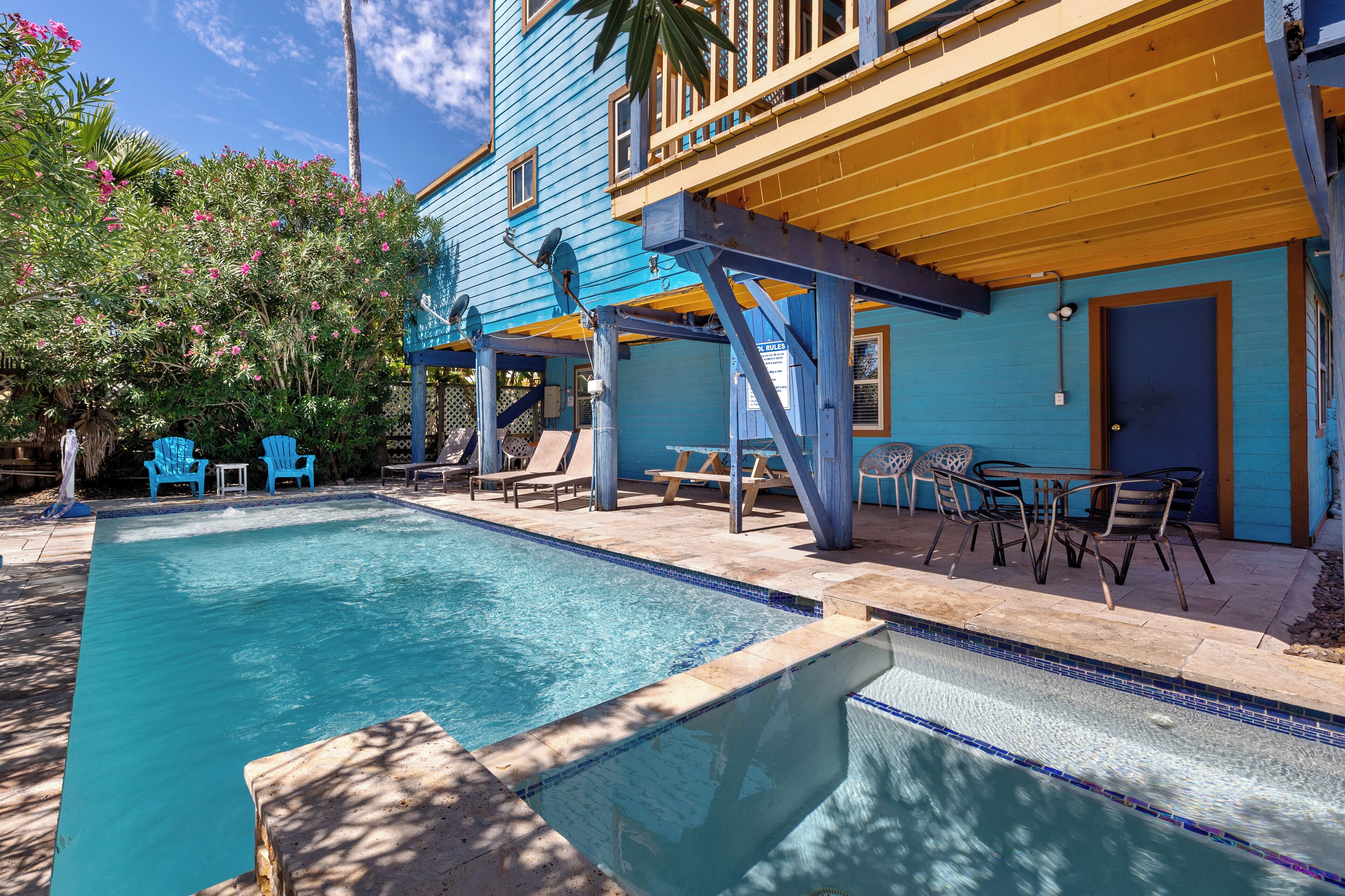 A pool area with blue chairs and a wooden deck.