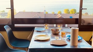 Ein Tisch für zwei Personen mit Blick auf das Meer und Gebäude im Hintergrund.