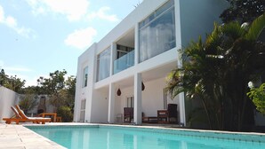 A modern two-story building with a swimming pool, outdoor seating, and lush greenery. - Toca do Sol com vista natureza em Pipa (Tibau do Sul)