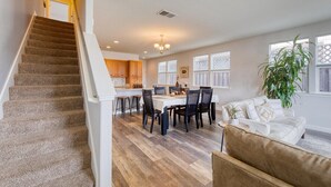 A spacious living area with a staircase, a dining table with chairs, and a sofa. - Russian River Brew-cation Home (Santa Rosa)