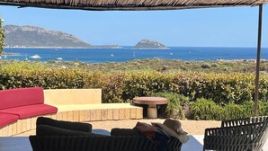 An outdoor seating area with a view of the sea and hills. - Villa Smeraldo (Sottomonte)