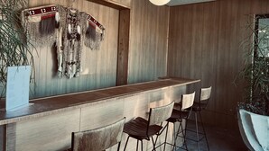 A bar area with wooden paneling, a hanging light fixture, and a menu board.