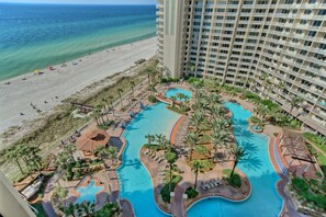 A resort with a pool area, beach access, and a high-rise building.