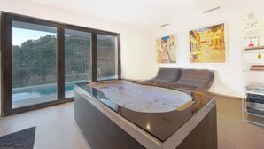Un baño moderno con una bañera grande, una cabina de ducha de vidrio y vistas a un paisaje montañoso.