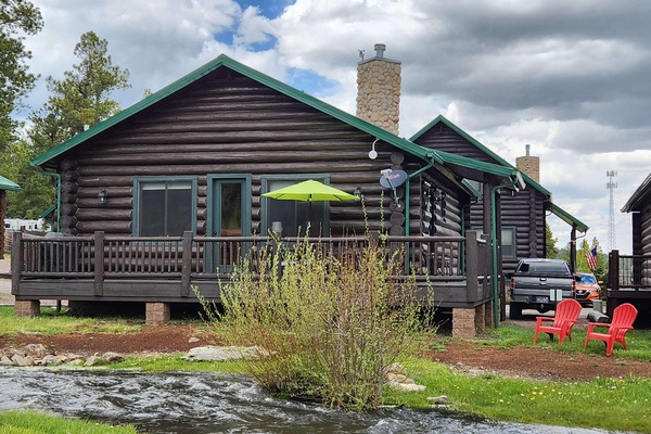 Back side of cabin facing ponds & meadow area. Just below the Adirondack chairs is Little Colorado River. A nice place to sit & fish or just enjoy the fresh air. Our porch has 3 cafe tables and six padded chairs next & propane grill. Gas provided.
