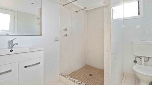 Un baño con ducha, lavamanos e inodoro.