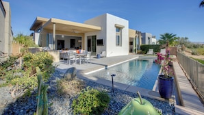 Una casa moderna con piscina, area relax esterna e giardino curato.
