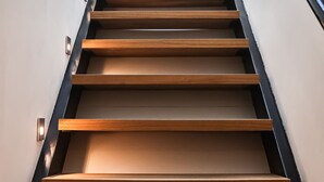 A modern staircase with wooden steps and metal railings. - Duplex Standing de 77m2 Avec Rooftop de vue mer Situé Plein Centre de Bandol (Bandol)