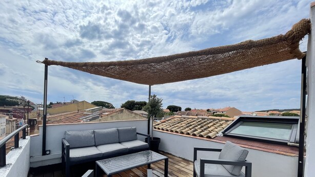 A rooftop terrace with a pergola, a sofa, a chair, and a table. - Duplex Standing de 77m2 Avec Rooftop de vue mer Situé Plein Centre de Bandol (Bandol)