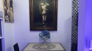 A dining area with a table, chairs, a decorative vase, and a painting on the wall. - Hollywood Art Studio Apartment (Los Angeles)