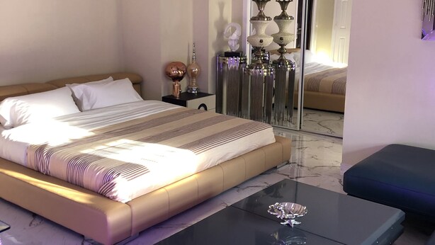 A modern bedroom with a large bed, a glass coffee table, and a sofa. - Hollywood Art Studio Apartment (Los Angeles)