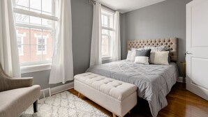A bedroom with a bed, a chair, a bench, and a ceiling fan. - ★ Stunning 3BR Modern Charm in South Philly ★ (Philadelphia)