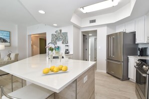 Uma cozinha moderna com ilha central, eletrodomésticos de aço inoxidável e design minimalista.